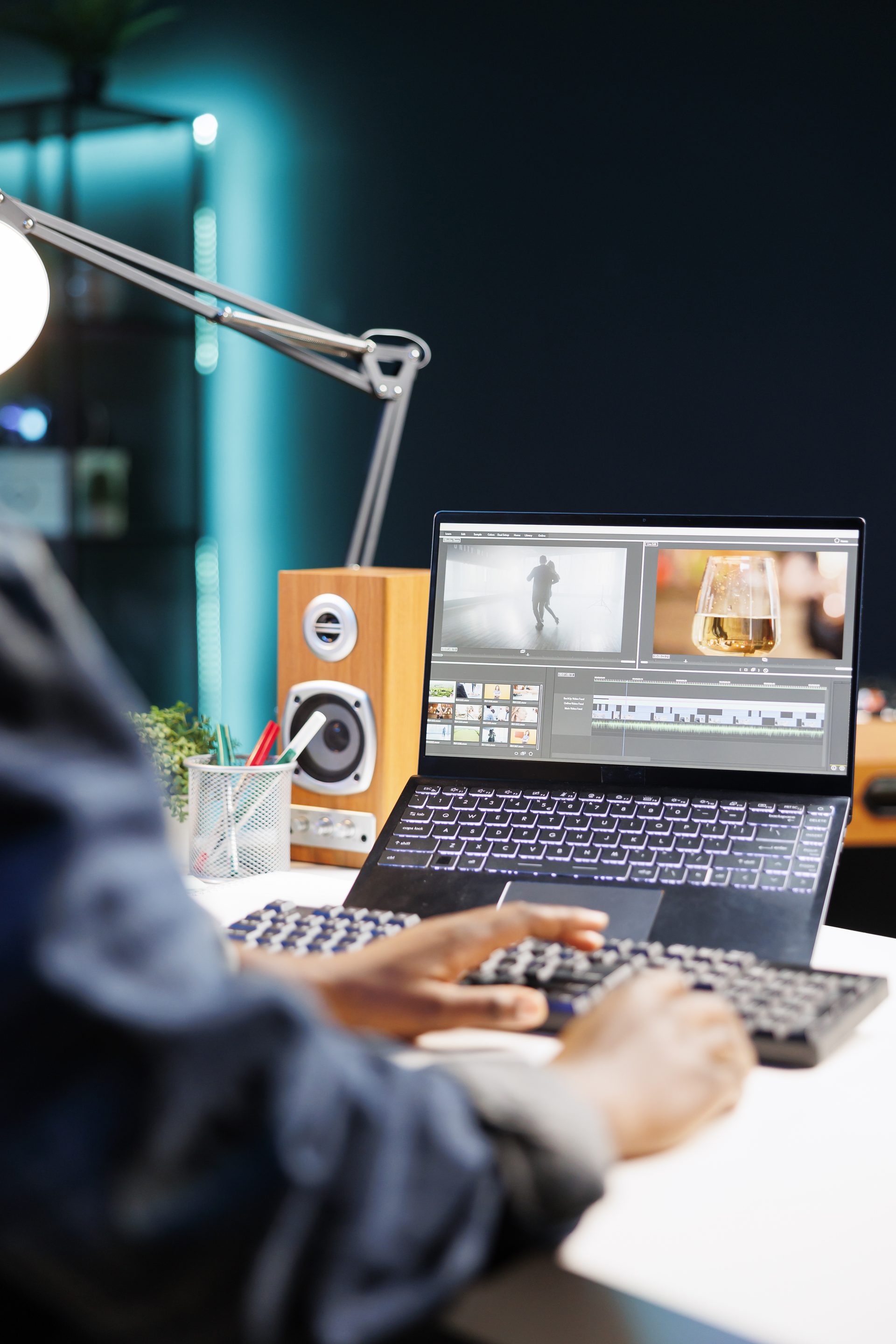 A developer at a backlit desk reviewing a project on screen